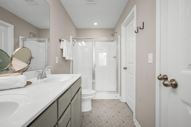 bathroom featuring vanity, toilet, and a shower with shower door