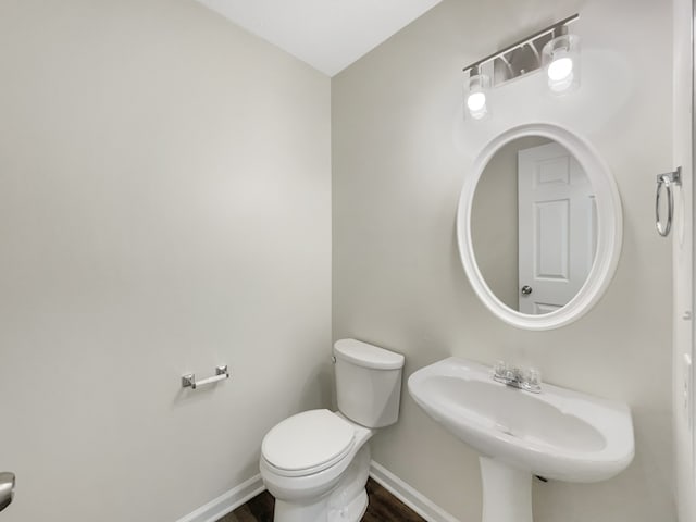 bathroom featuring toilet, sink, and hardwood / wood-style floors