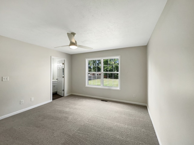 carpeted spare room featuring a textured ceiling and ceiling fan