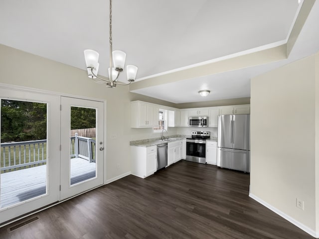 kitchen featuring sink, dark wood-type flooring, hanging light fixtures, appliances with stainless steel finishes, and white cabinets