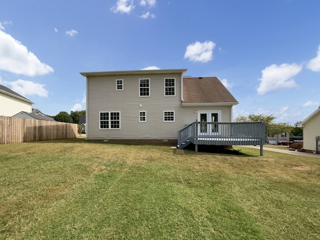 rear view of house featuring a yard and a deck