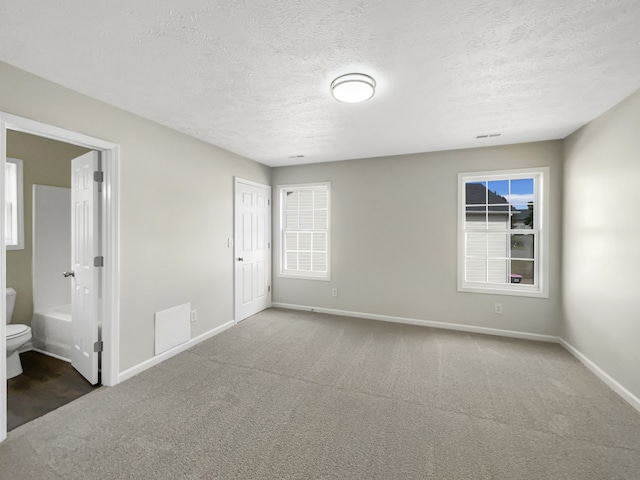 carpeted spare room with a textured ceiling