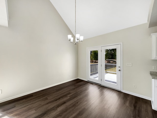 unfurnished dining area with dark wood-type flooring, vaulted ceiling, and an inviting chandelier