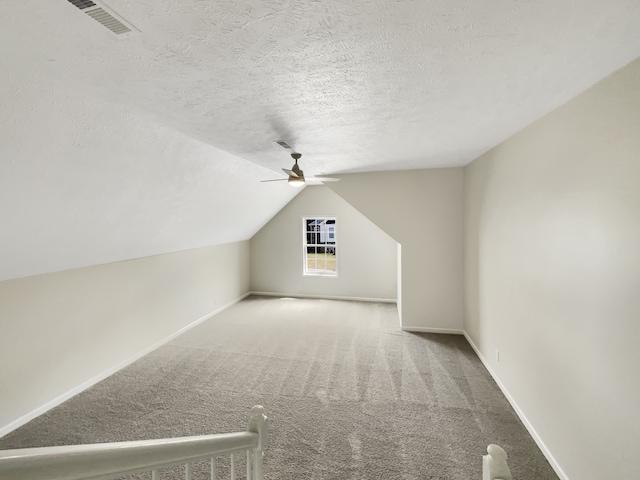 bonus room featuring ceiling fan, carpet floors, a textured ceiling, and vaulted ceiling