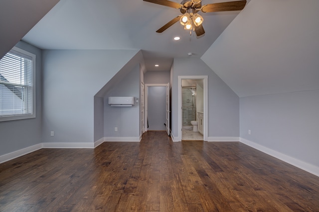 bonus room with lofted ceiling, dark wood-type flooring, ceiling fan, and a wall mounted air conditioner