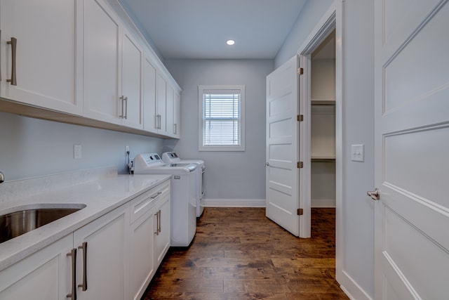 washroom featuring cabinets, sink, dark wood-type flooring, and washer and dryer