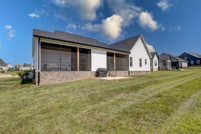 back of house with a sunroom and a lawn