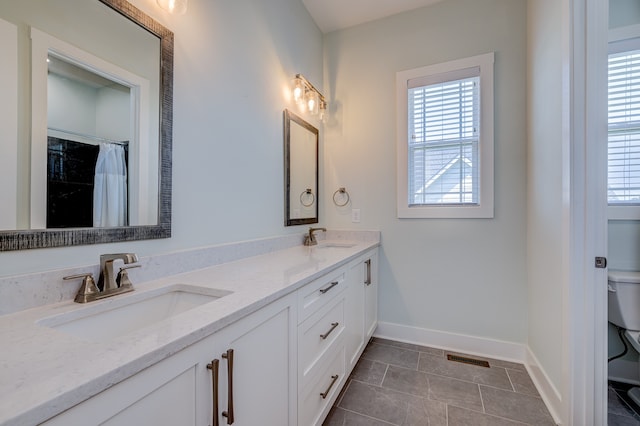 bathroom featuring vanity, toilet, tile patterned floors, and plenty of natural light