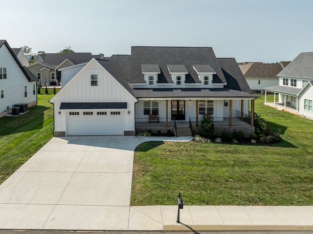 view of front facade with a front yard, cooling unit, a garage, and a porch