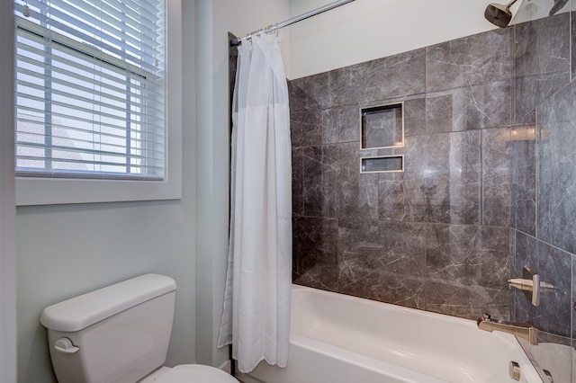 bathroom featuring shower / bath combination with curtain and toilet