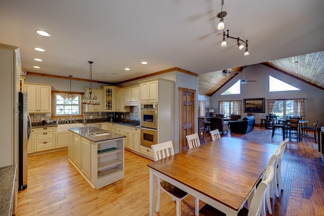 dining room featuring vaulted ceiling, ceiling fan, light hardwood / wood-style floors, and a healthy amount of sunlight