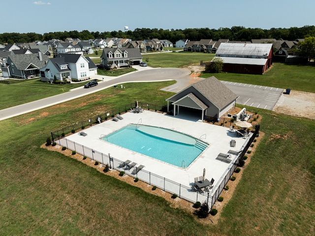 view of pool with a lawn and an outbuilding