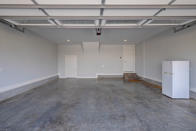 garage featuring a garage door opener and white refrigerator