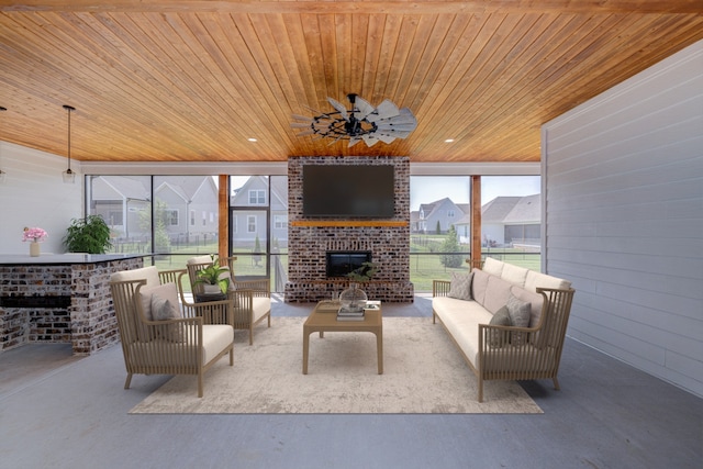 interior space featuring wood ceiling, concrete flooring, ceiling fan, and a fireplace