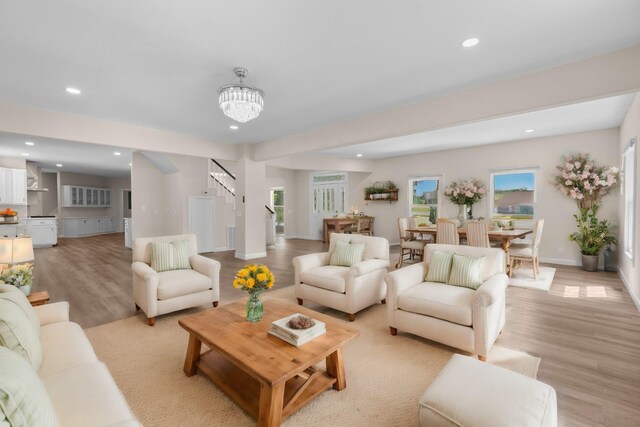 living room with light wood-type flooring and a chandelier