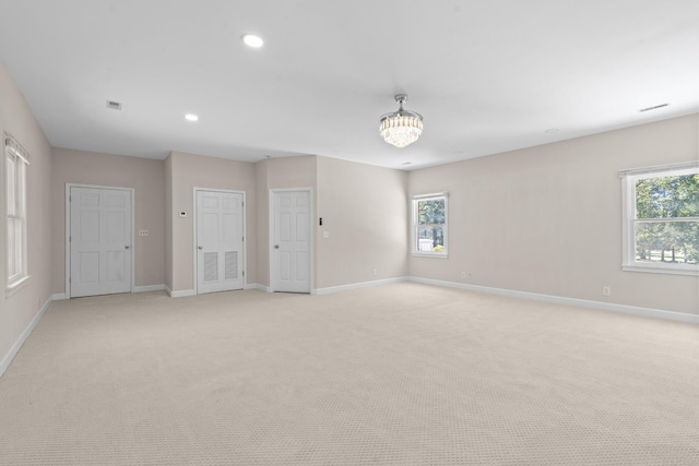 unfurnished room with a wealth of natural light, baseboards, and light carpet