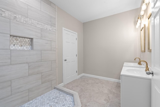 full bathroom featuring double vanity, baseboards, and a sink