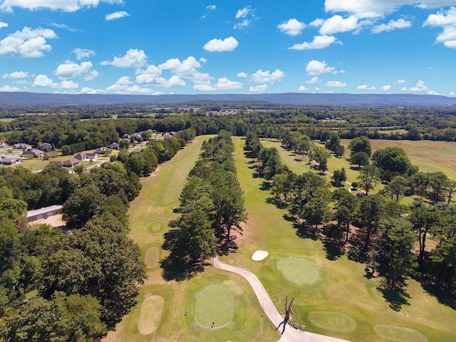 drone / aerial view with view of golf course and a view of trees