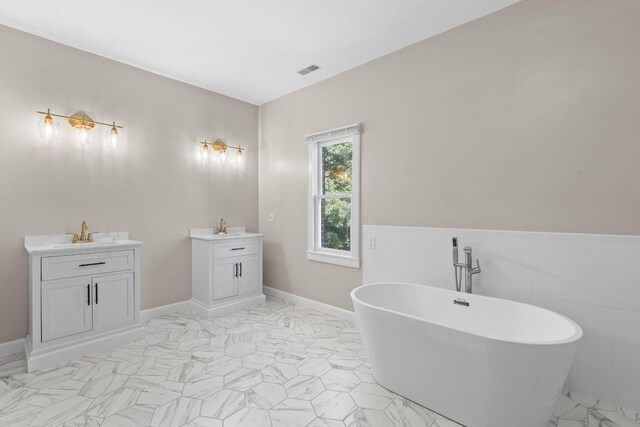 bathroom with vanity, tile walls, and a bathing tub