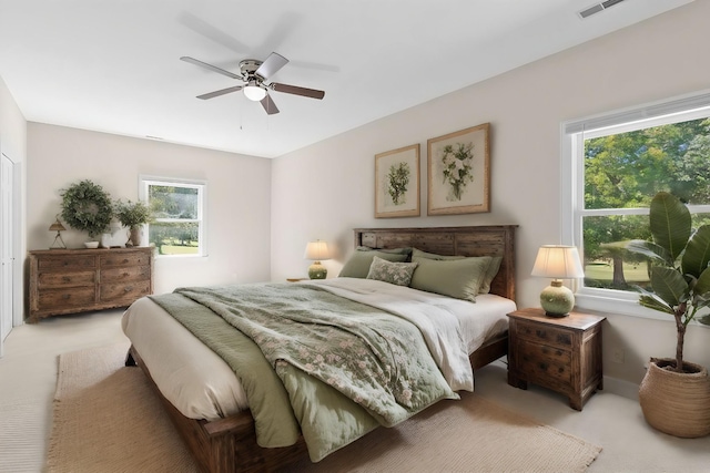 bedroom featuring light carpet, visible vents, and ceiling fan