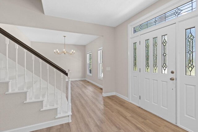 entryway with light wood-type flooring and a notable chandelier