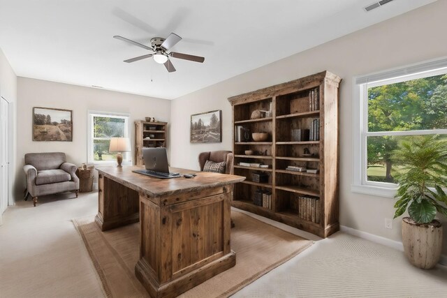 office area featuring ceiling fan, light carpet, and a healthy amount of sunlight