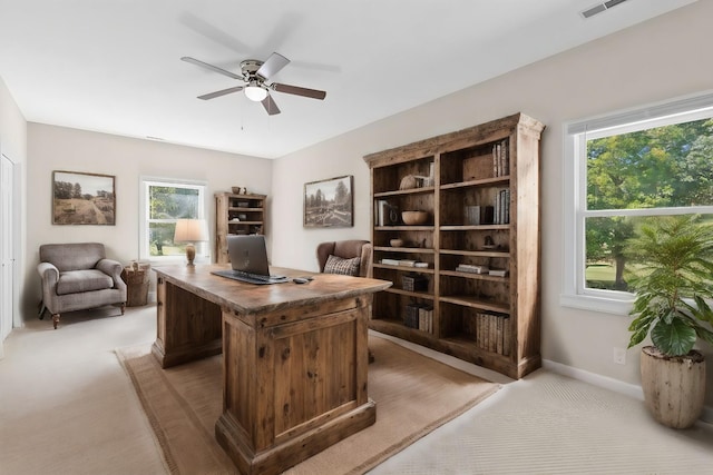 home office with visible vents, baseboards, light colored carpet, and ceiling fan