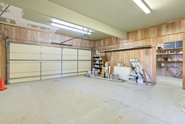 garage with a garage door opener and wooden walls