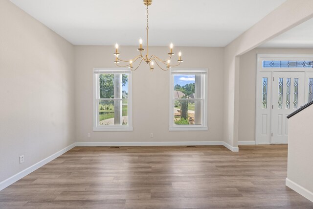 interior space with wood-type flooring and a notable chandelier