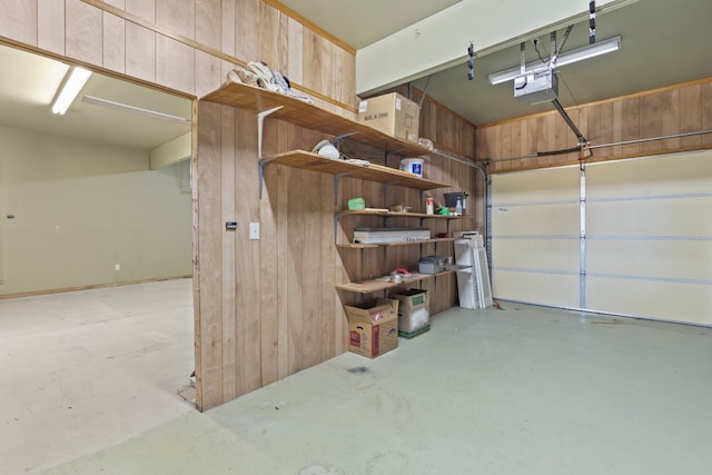 garage featuring a garage door opener and wooden walls