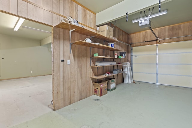 garage featuring a garage door opener and wood walls