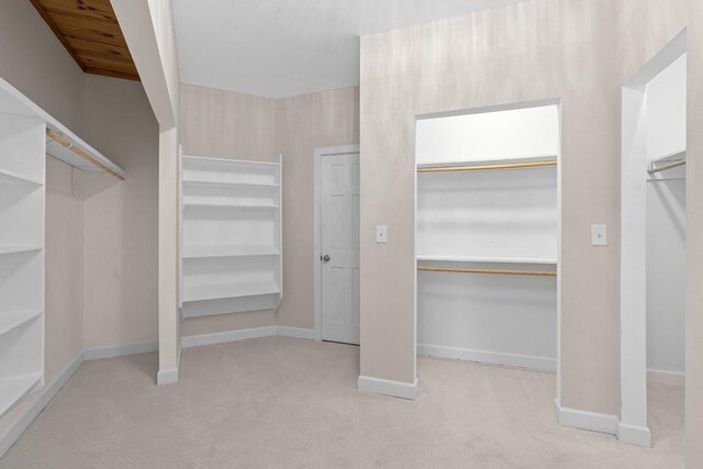 walk in closet featuring light carpet