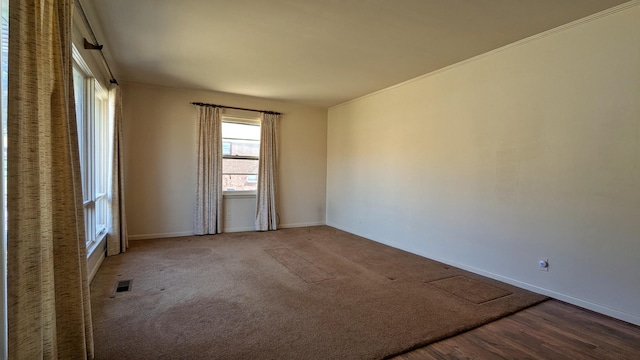 carpeted empty room with visible vents and baseboards