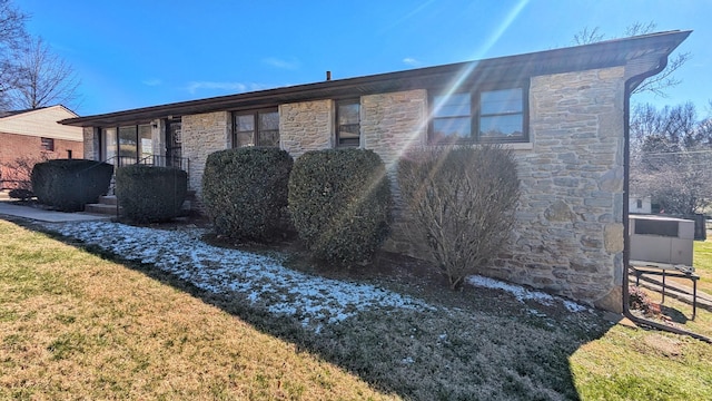 view of property exterior featuring stone siding and a lawn