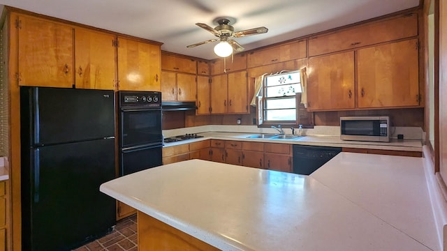 kitchen with light countertops, a sink, ceiling fan, under cabinet range hood, and black appliances