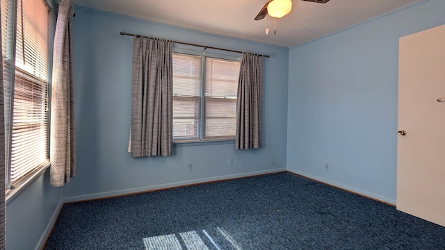 unfurnished room with ornamental molding, dark carpet, a ceiling fan, and baseboards