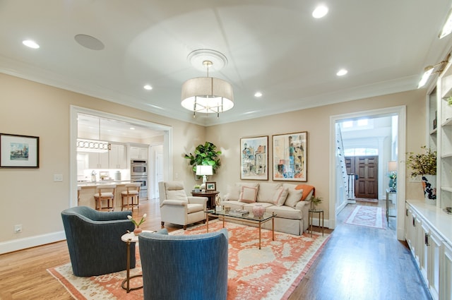 living room featuring ornamental molding and light hardwood / wood-style floors