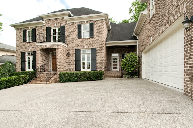 view of front facade featuring a garage and a balcony