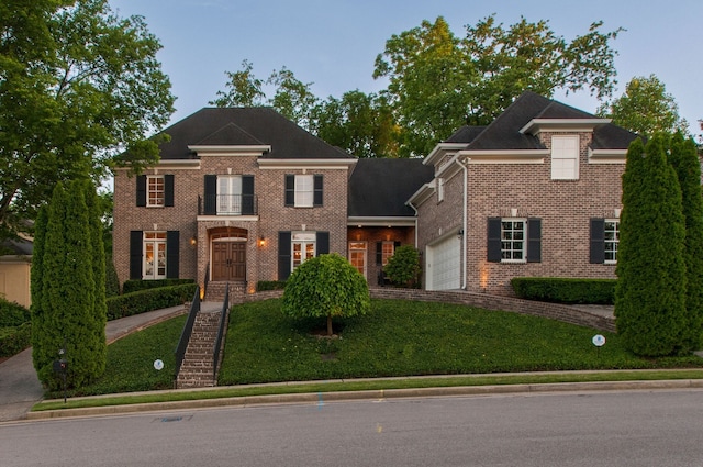 colonial home with a garage and a front yard