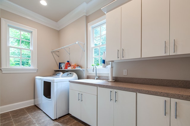 clothes washing area featuring separate washer and dryer, a healthy amount of sunlight, cabinets, and sink