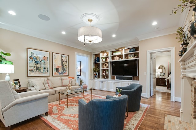 living room with crown molding, a fireplace, and light hardwood / wood-style flooring