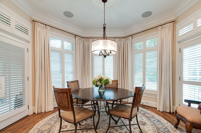 dining room with wood-type flooring, a chandelier, and ornamental molding