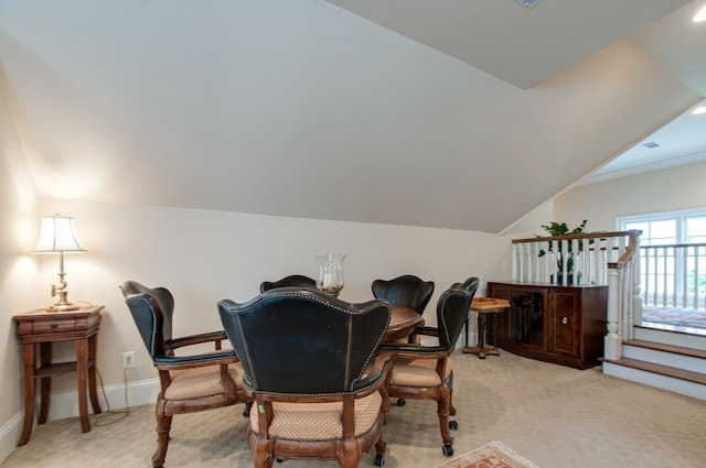 dining room featuring lofted ceiling and light colored carpet