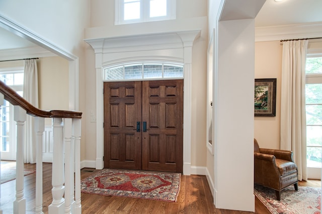 foyer featuring crown molding, plenty of natural light, and hardwood / wood-style floors