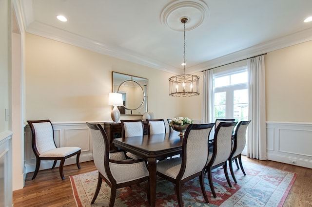 dining room with dark wood-type flooring, a chandelier, and ornamental molding