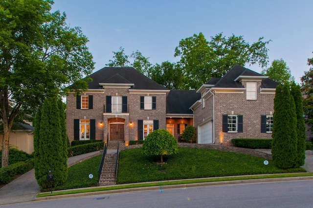 colonial house featuring a garage and a lawn