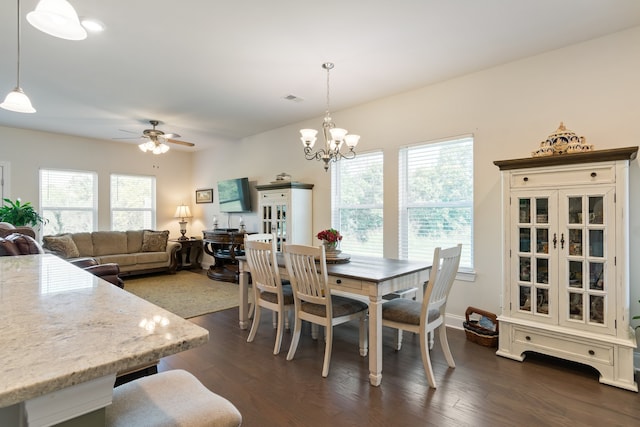 dining space featuring ceiling fan with notable chandelier and dark hardwood / wood-style floors