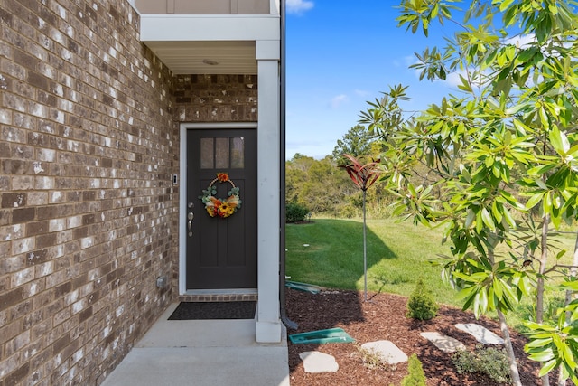 property entrance with a lawn