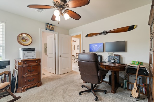 carpeted home office featuring ceiling fan