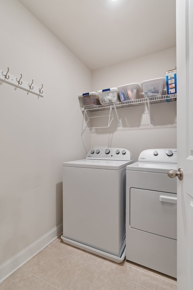 laundry room featuring washer and dryer and light tile patterned floors